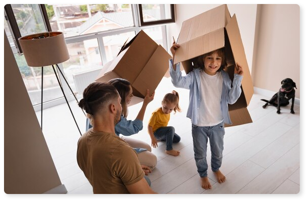 Μια οικογένεια παίζει χαρούμενη με τις κούτες της μετακόμισης και απολαμβάνει το νέο της σπίτι, το οποίο αγόρασε με στεγαστικό δάνειο.